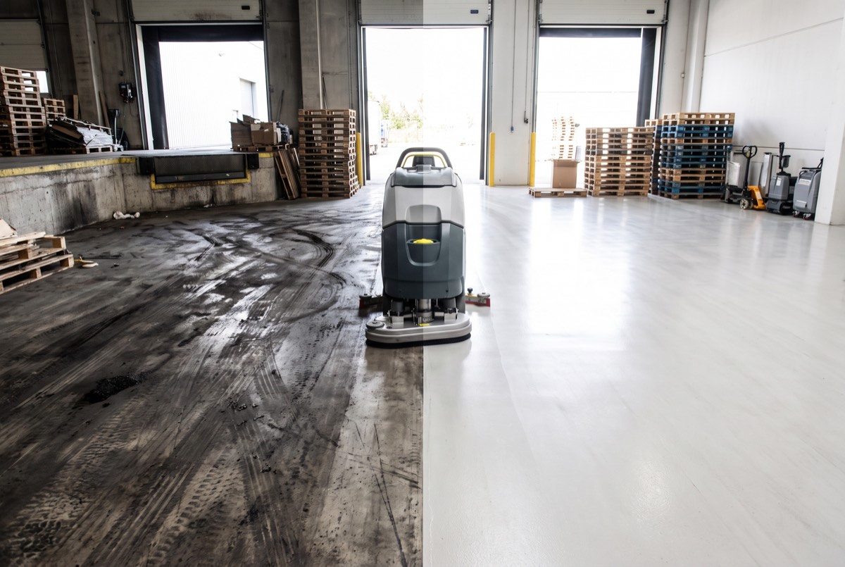 Warehouse floor half cleaned, showing dramatic before and after at a Grayson County facility